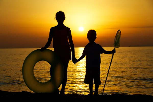 Kids silhouettes on beach — Stock Photo, Image