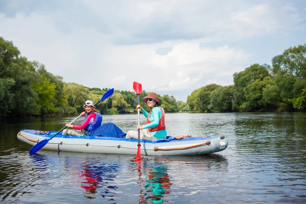 Flicka med sin mamma kajakpaddling — Stockfoto