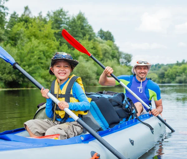 Pojken med sin far kajakpaddling — Stockfoto