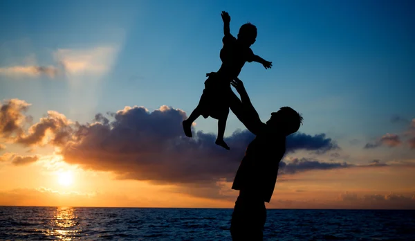 Silhouetten am Strand bei Sonnenuntergang — Stockfoto