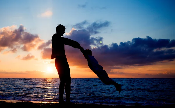 Silhouetten am Strand bei Sonnenuntergang — Stockfoto