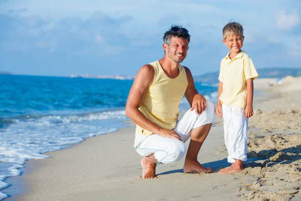 Far och son på stranden — Stockfoto