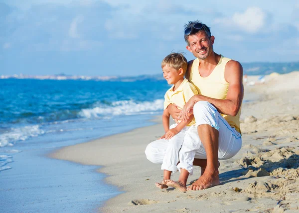 Far och son på stranden — Stockfoto