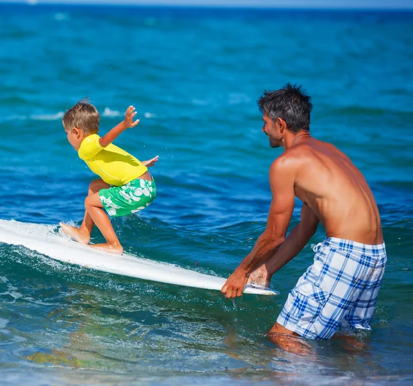 Father and Son Going Surfing Together on Tropical Beach in Hawai Stock
