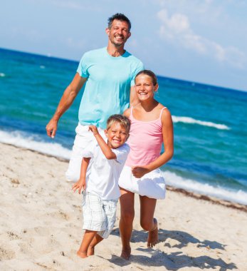 Çocuklar ve sahilde oynarken baba.