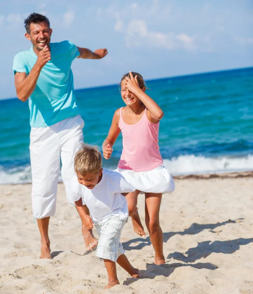 Crianças e pai brincando na praia . — Fotografia de Stock