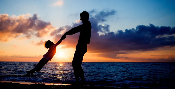 Silhouettes at sunset beach — Stock Photo, Image