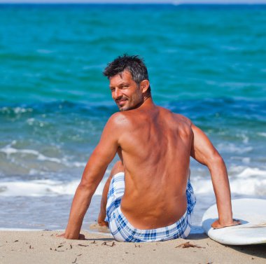 adam sahilde onun surfboard ile
