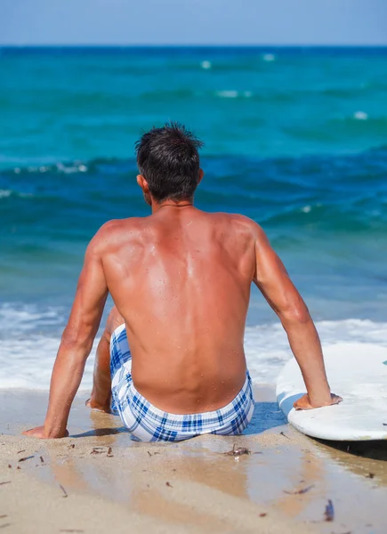 Hombre con su tabla de surf en la playa —  Fotos de Stock