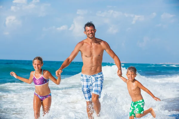 Pai e filhos brincando na praia — Fotografia de Stock