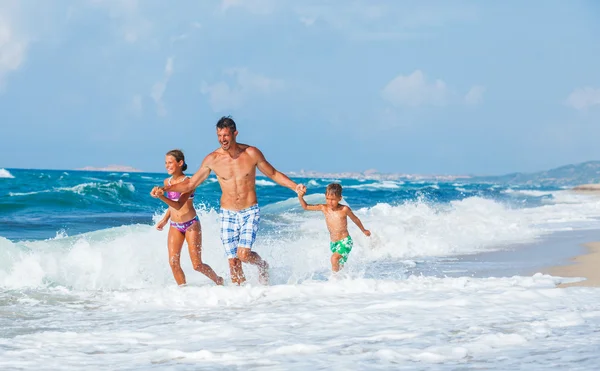 Pai e filhos brincando na praia — Fotografia de Stock