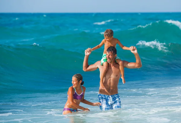 Vader en kinderen spelen in de zee — Stockfoto