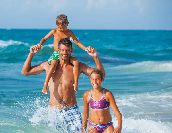 Père et enfants jouant dans la mer — Photo