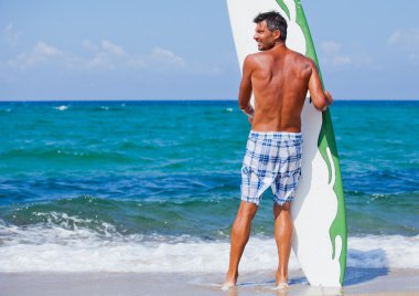 adam sahilde onun surfboard ile