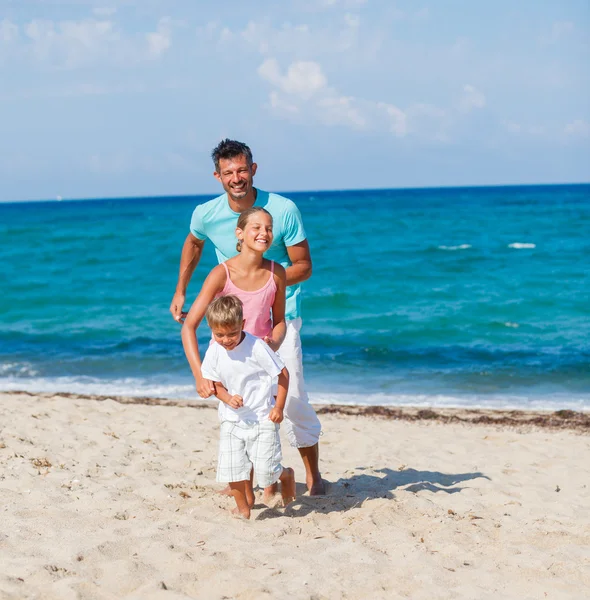 Crianças e pai brincando na praia . — Fotografia de Stock