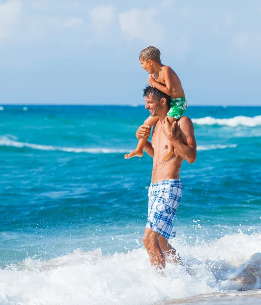 Far och son leker i havet — Stockfoto