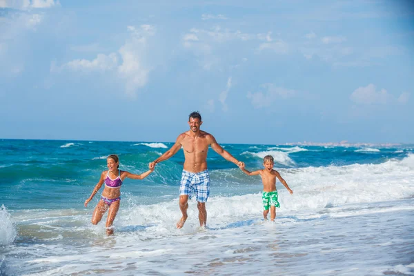 Pai e filhos brincando na praia — Fotografia de Stock