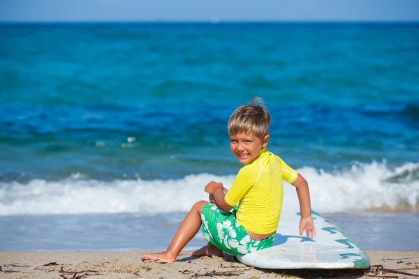 Мальчик с доской для серфинга — стоковое фото