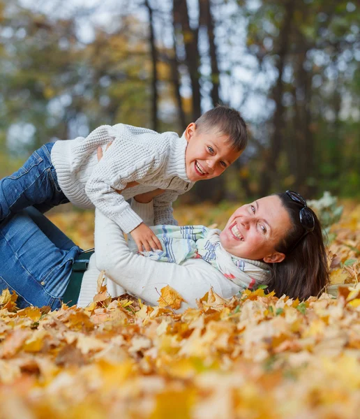 Bedårande pojke med sin mamma i höst park — Stockfoto