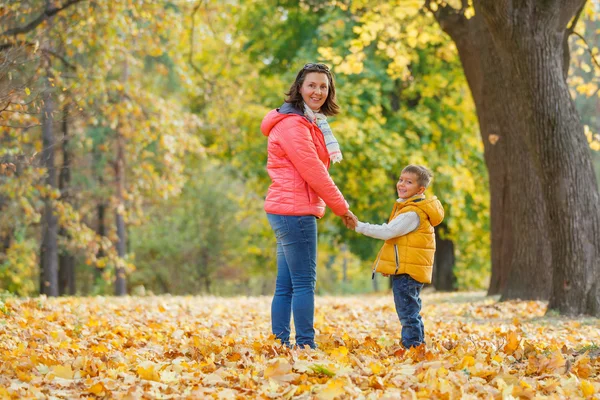 Entzückender Junge mit seiner Mutter im Herbstpark — Stockfoto