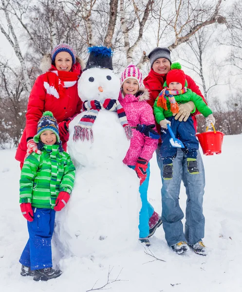 Família com um boneco de neve — Fotografia de Stock