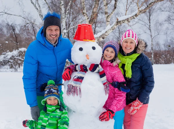 Família com um boneco de neve — Fotografia de Stock