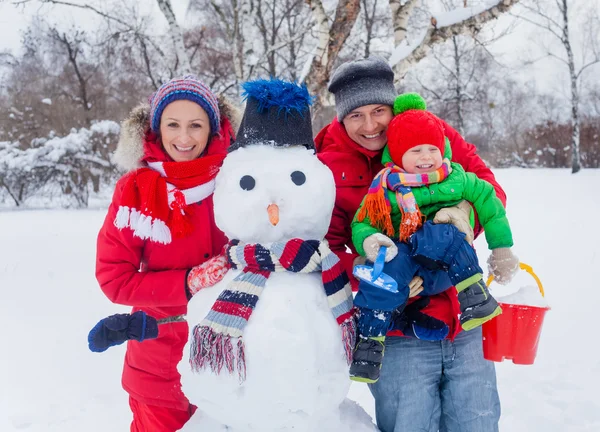 Rodina s sněhulák — Stock fotografie