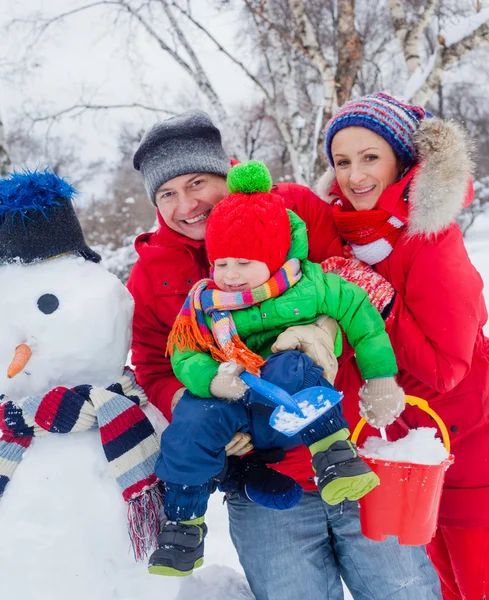 Familie mit einem Schneemann — Stockfoto