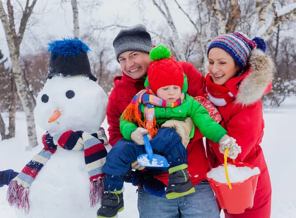 Família com um boneco de neve — Fotografia de Stock