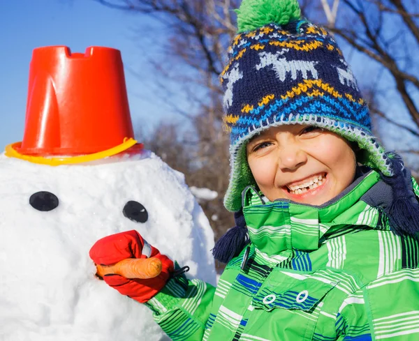 Chico hace un muñeco de nieve —  Fotos de Stock
