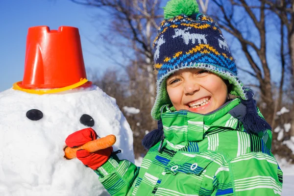 Pojke gör en snögubbe — Stockfoto