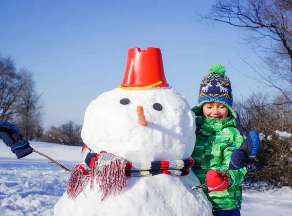 Pojke gör en snögubbe — Stockfoto