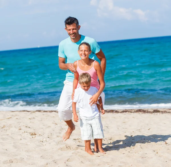 Niños y padre jugando en la playa . — Foto de Stock