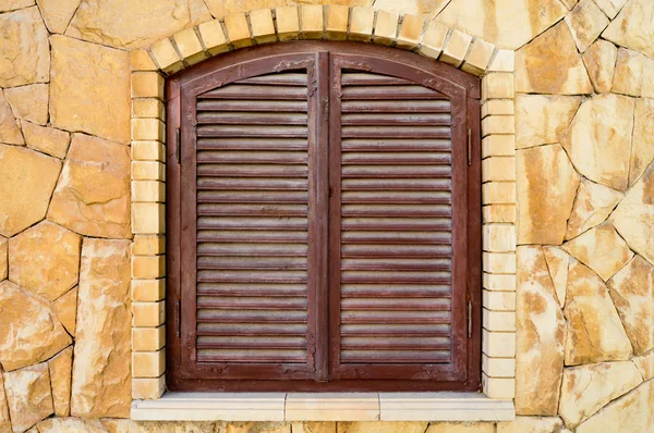 Braune Fensterläden und Steinmauer — Stockfoto