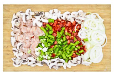 Organik taze biberli soğan mantarı çiğ tavuk eti, bambu kesme tahtasındaki çeşitli kesilmiş sebzeler.