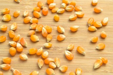 Sarı mısır taneleri patlamış mısır yapmaya hazır, bambu kesme tahtasının üzerinde.