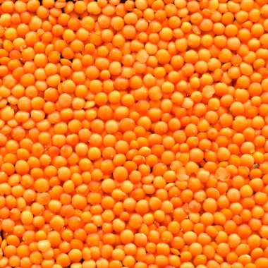 Kuru kırmızı ve turuncu organik mercimek tanecikleri çiğ doku, bambu kesme tahtası üzerinde.