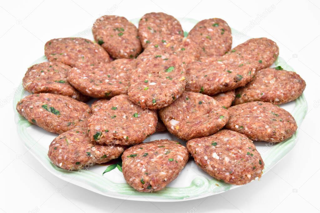 Raw beef meatballs made with various homemade spices, beef kofte kofta raw, in a white plate