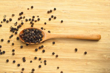 Tahta bambu kesme tahtasının üzerinde kaşık içinde Aromatik ve taze biber.