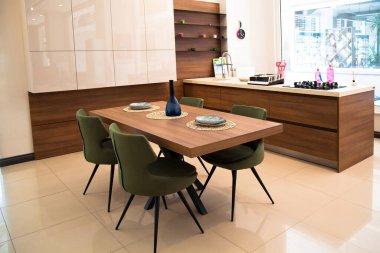 Modern mutfak iç alanı, ahşap ceviz yemek masası ve yeşil sandalyeler.