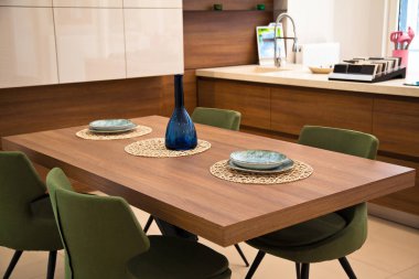 Modern mutfak iç alanı, ahşap ceviz yemek masası ve yeşil sandalyeler.