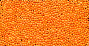 Kuru kırmızı ve turuncu organik mercimek tanecikleri çiğ doku, bambu kesme tahtası üzerinde.