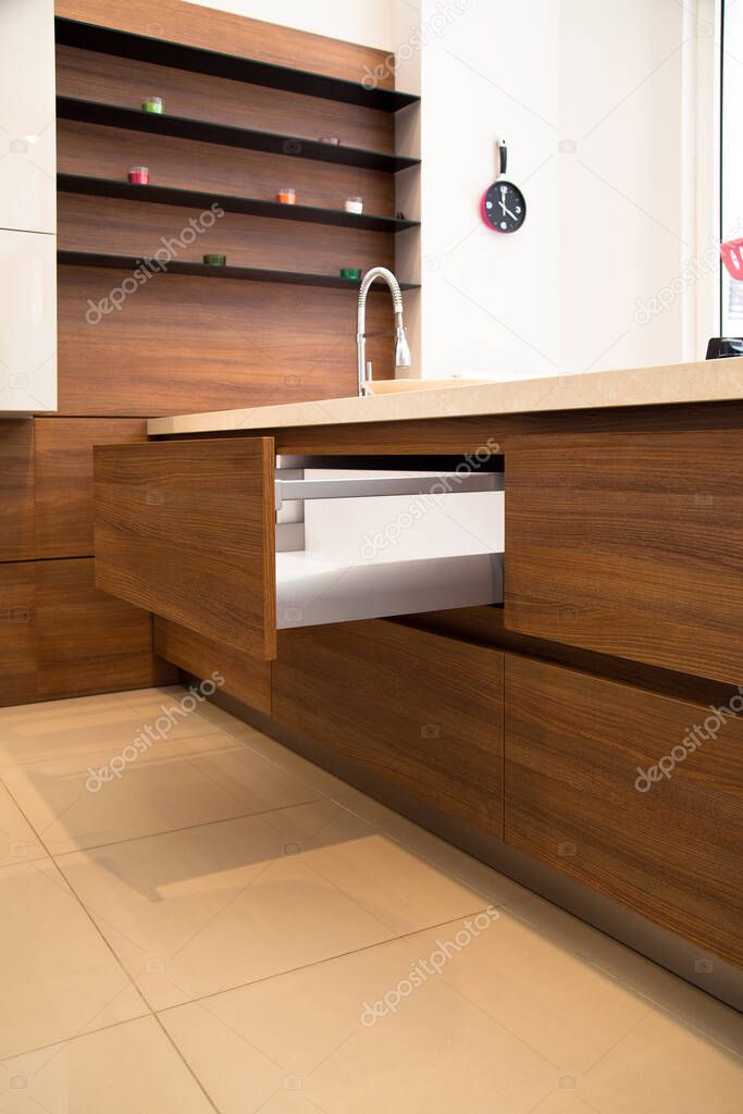 Interior of luxurious modern kitchen equipment, white and walnut cabinets