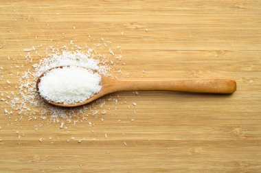 Tahta kaşık içinde taze ve besleyici hindistan cevizi, bambu kesme tahtasında.