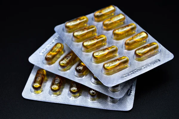 Tabletki Owalne Żółte Olej Rybny Pakowane Izolowane Czarnym Tle Tabletki — Zdjęcie stockowe