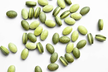 Beyaz arka planda izole edilmiş yeşil oval tablet haplar, tıbbi oval haplar