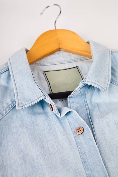 Light blue denim shirt, collar and button detail, close-up blue jean shirt