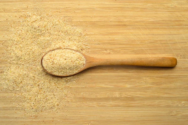新鲜可口的面包在褐色竹子切菜板上的木制勺子中揉碎了加莱塔面粉 — 图库照片