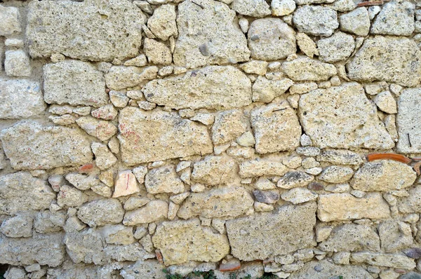 Velho muro de pedra feito de várias pedras naturais quadradas em