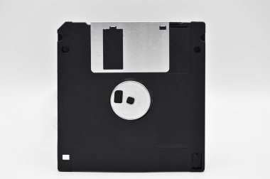 Eski bilgisayar ve veri depolama teknolojisi, siyah plastik manyetik disk 3.5 inç, beyaz arka planda izole edilmiş.